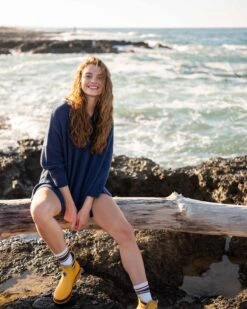 Montauk V-neck Sweater -Mersea womens dark blue midweight loose fitting v neck sweater front view sitting travel destination look