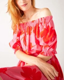 Ibiza Dress 24 Ibiza Dress -Mersea womens floral pink ruffled shoulder midi dress sitting front view arms crossed