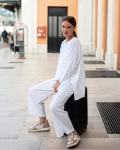 Traveler Tee Pant -Mersea womens white wide leg ankle side slit elastic waist pant side view sitting travel destination look